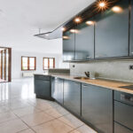 Bright kitchen with black kitchen set and tiled floor